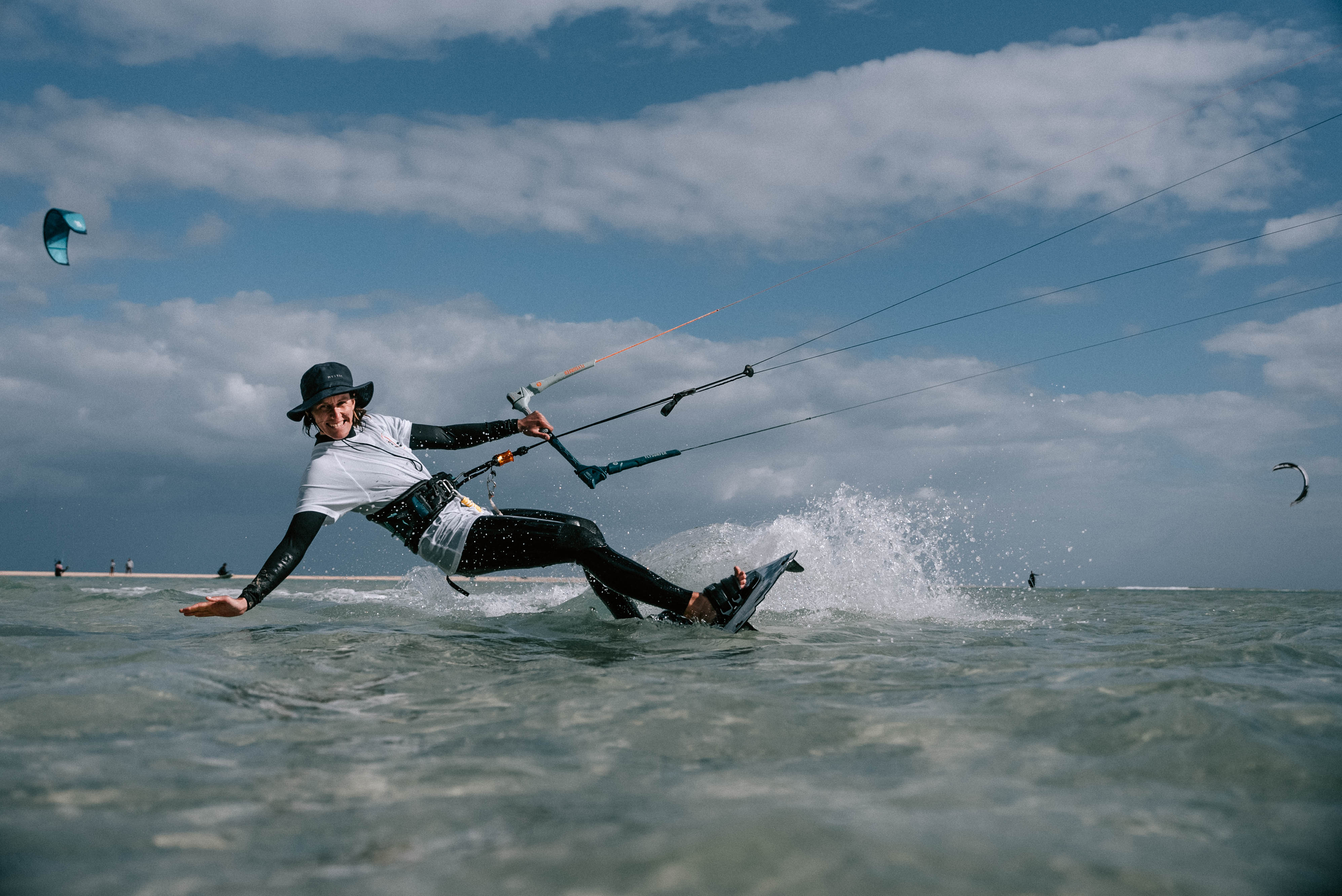 Johanna fährt dynamisch mit dem Kite durch das Wasser